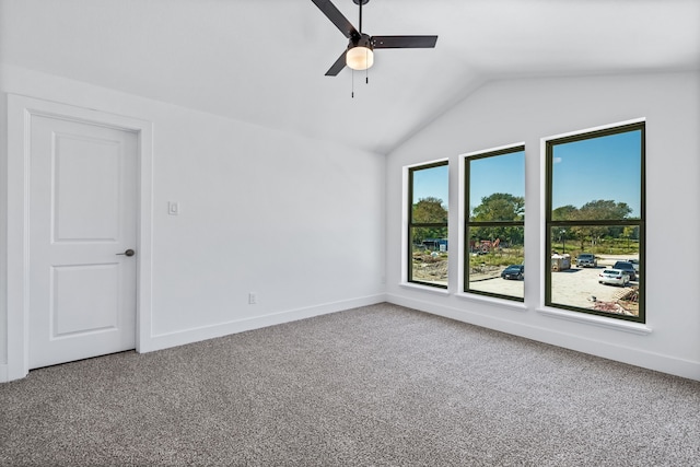 carpeted spare room with ceiling fan and vaulted ceiling