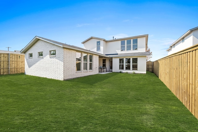 rear view of house featuring a yard and a patio