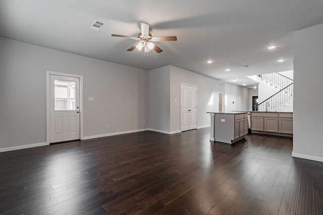 unfurnished living room featuring dark hardwood / wood-style floors and ceiling fan