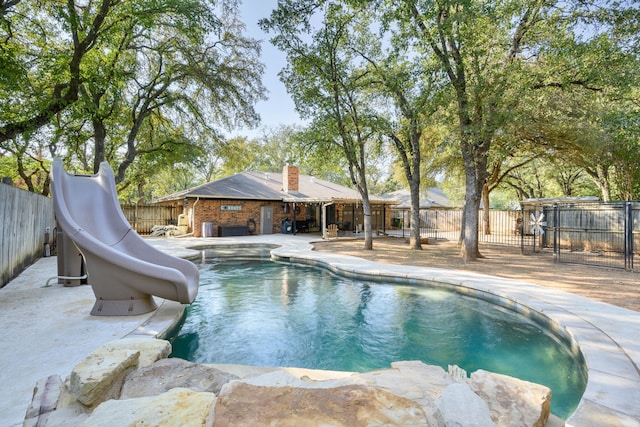 view of swimming pool featuring a water slide and a patio area