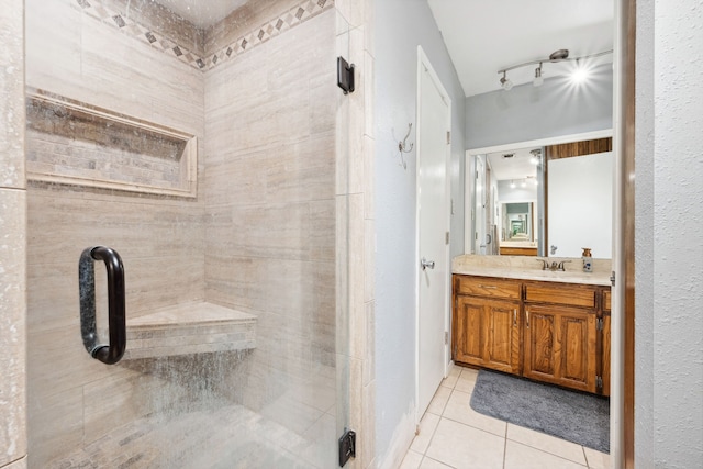 bathroom with tile patterned flooring, vanity, and a shower with shower door