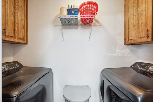 laundry area featuring washing machine and dryer and cabinets