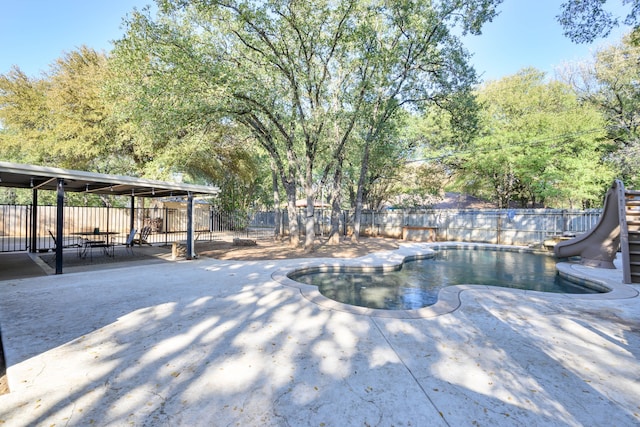 view of pool featuring a water slide and a patio area