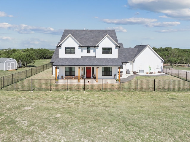 view of front of home featuring a patio area, a front yard, and a storage unit