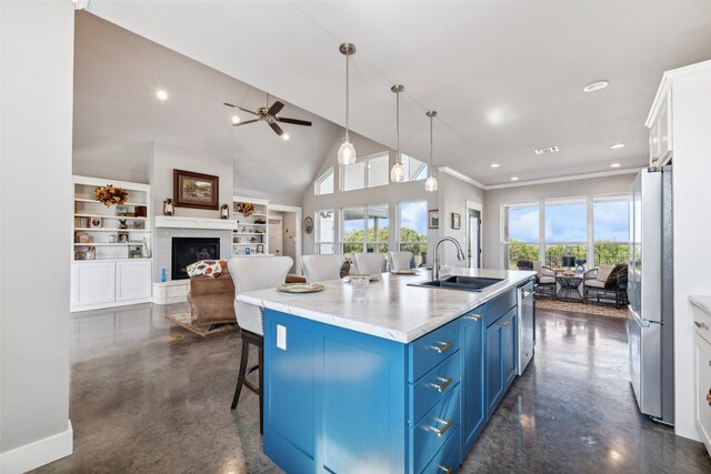 kitchen with white cabinets, an island with sink, sink, blue cabinetry, and appliances with stainless steel finishes