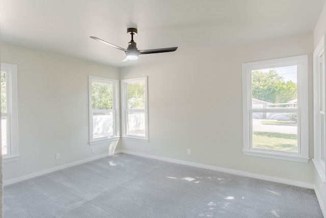 carpeted spare room with ceiling fan and plenty of natural light