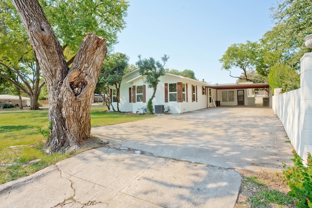 ranch-style home with a front yard, cooling unit, and a carport