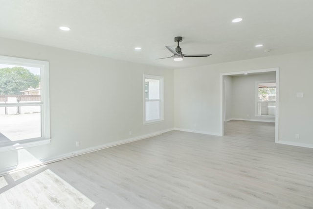 empty room featuring ceiling fan, light hardwood / wood-style flooring, and a healthy amount of sunlight