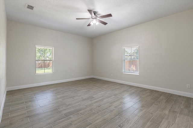 empty room featuring ceiling fan, a textured ceiling, and light wood-type flooring