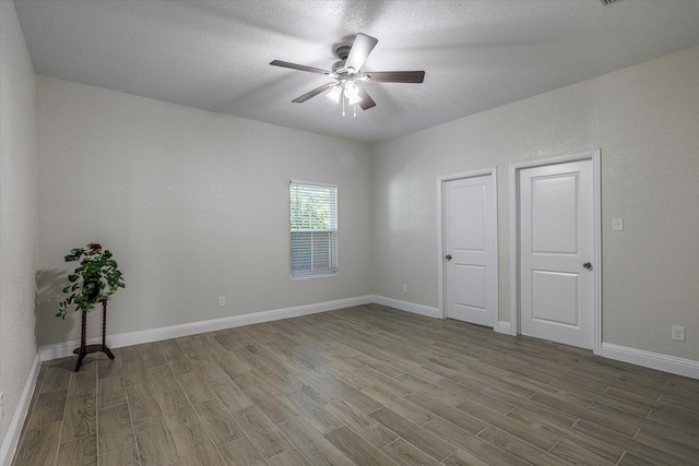 spare room featuring ceiling fan, hardwood / wood-style flooring, and a textured ceiling