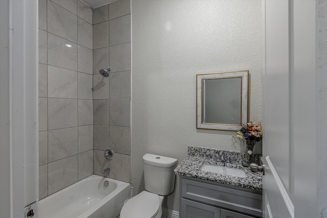 full bathroom featuring tiled shower / bath, vanity, and toilet