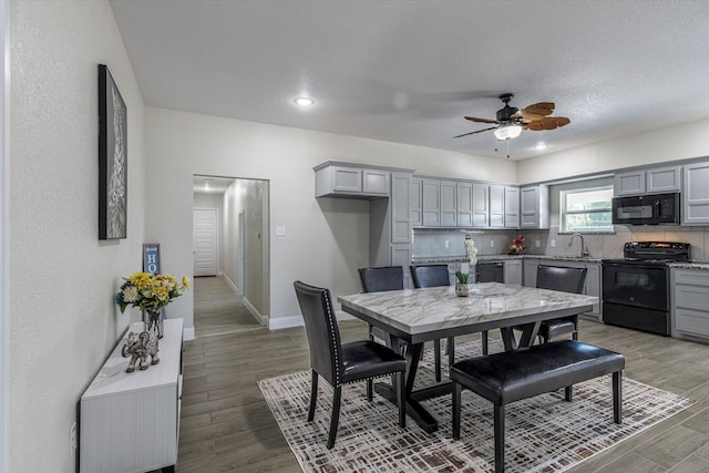 dining space featuring ceiling fan, hardwood / wood-style flooring, a textured ceiling, and sink