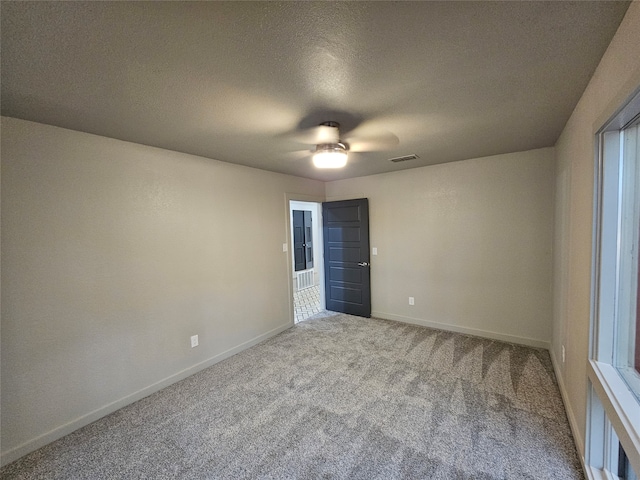 empty room with carpet floors, a textured ceiling, and ceiling fan