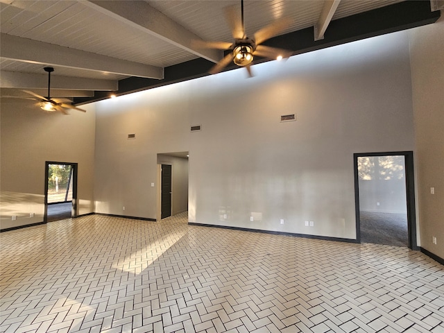 unfurnished living room featuring ceiling fan, beamed ceiling, and a high ceiling