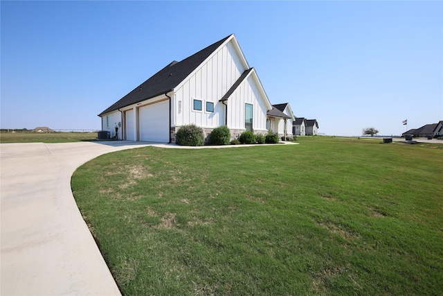 view of side of property with central air condition unit, a yard, and a garage