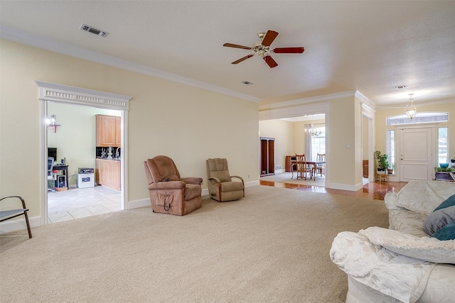 living room with ceiling fan with notable chandelier, crown molding, and light colored carpet