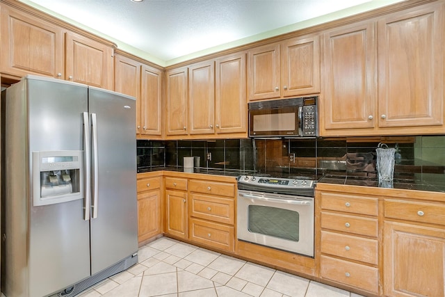 kitchen featuring stainless steel appliances, backsplash, and light tile patterned floors