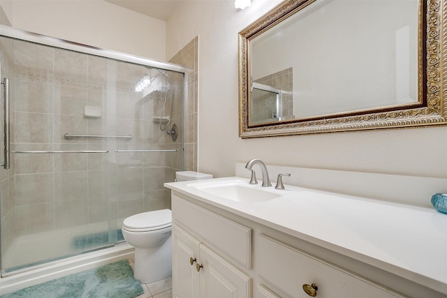 bathroom featuring vanity, toilet, a shower with shower door, and tile patterned flooring