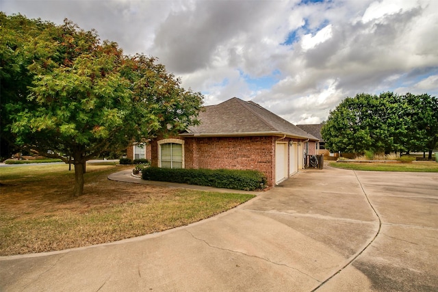 view of property exterior with a garage and a lawn