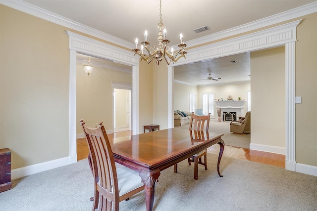 dining area featuring ornamental molding, hardwood / wood-style floors, and ceiling fan with notable chandelier