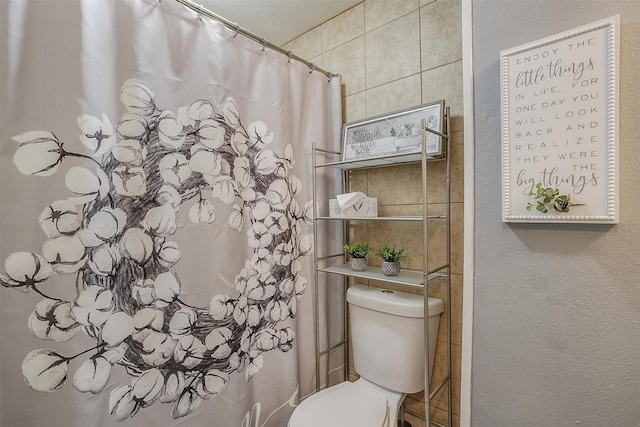 bathroom featuring a shower with curtain and toilet