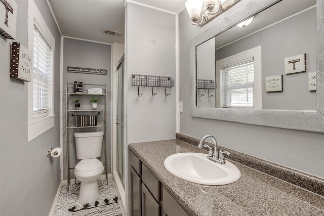 bathroom with tile patterned flooring, vanity, a shower with door, and toilet