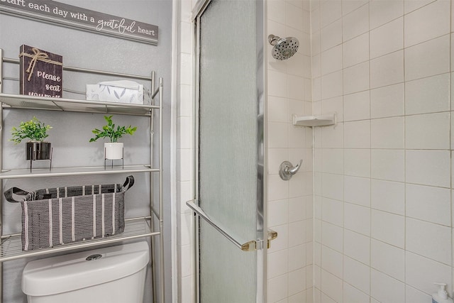 bathroom featuring an enclosed shower and toilet