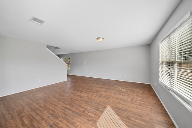 empty room featuring dark hardwood / wood-style floors and a healthy amount of sunlight