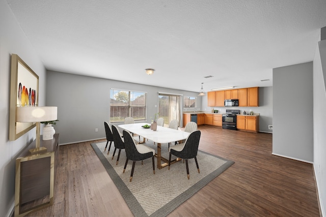 dining space featuring a textured ceiling and dark hardwood / wood-style flooring