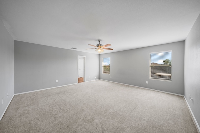 carpeted spare room with ceiling fan