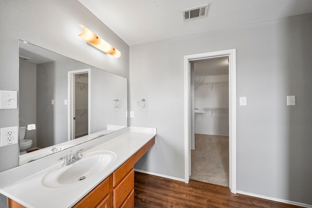 bathroom featuring vanity, toilet, and hardwood / wood-style floors