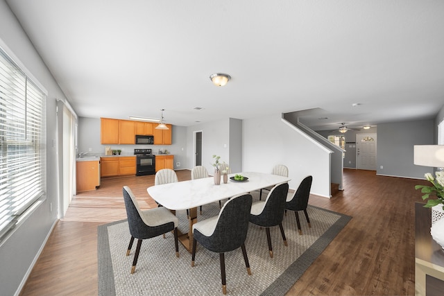 dining room with ceiling fan, sink, and dark hardwood / wood-style flooring