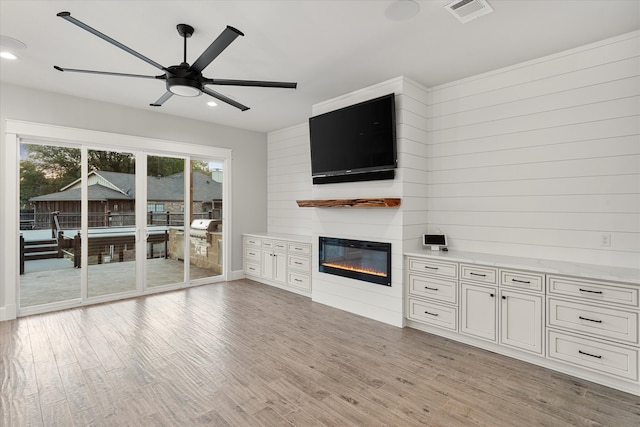 unfurnished living room with ceiling fan and light hardwood / wood-style flooring