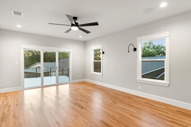 spare room featuring ceiling fan, light wood-type flooring, and plenty of natural light