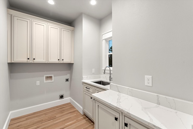 laundry room featuring sink, cabinets, hookup for a washing machine, light wood-type flooring, and electric dryer hookup