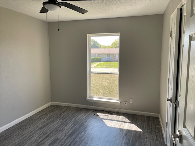 empty room featuring ceiling fan, a textured ceiling, and dark hardwood / wood-style flooring