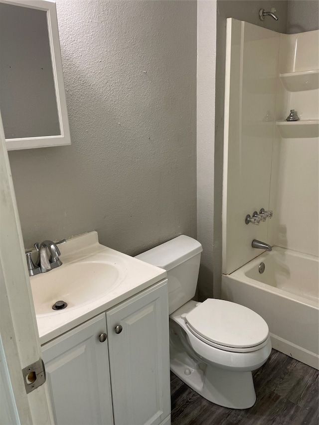 full bathroom featuring hardwood / wood-style floors, toilet, vanity, and  shower combination