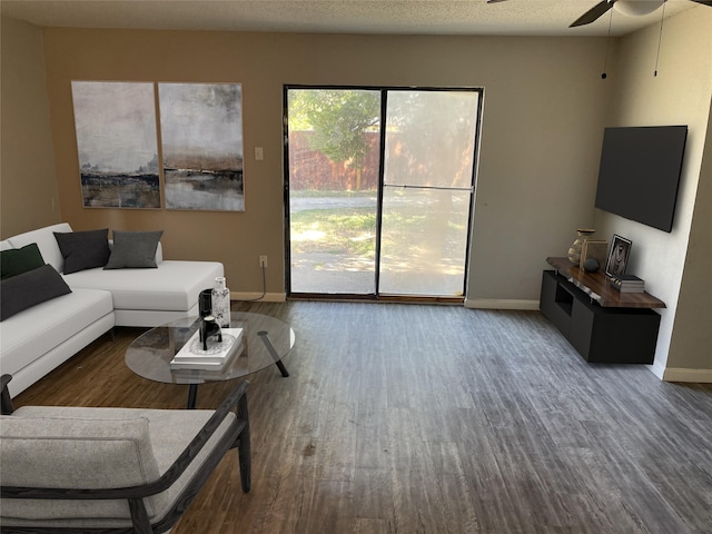 living room with ceiling fan, a textured ceiling, and hardwood / wood-style floors