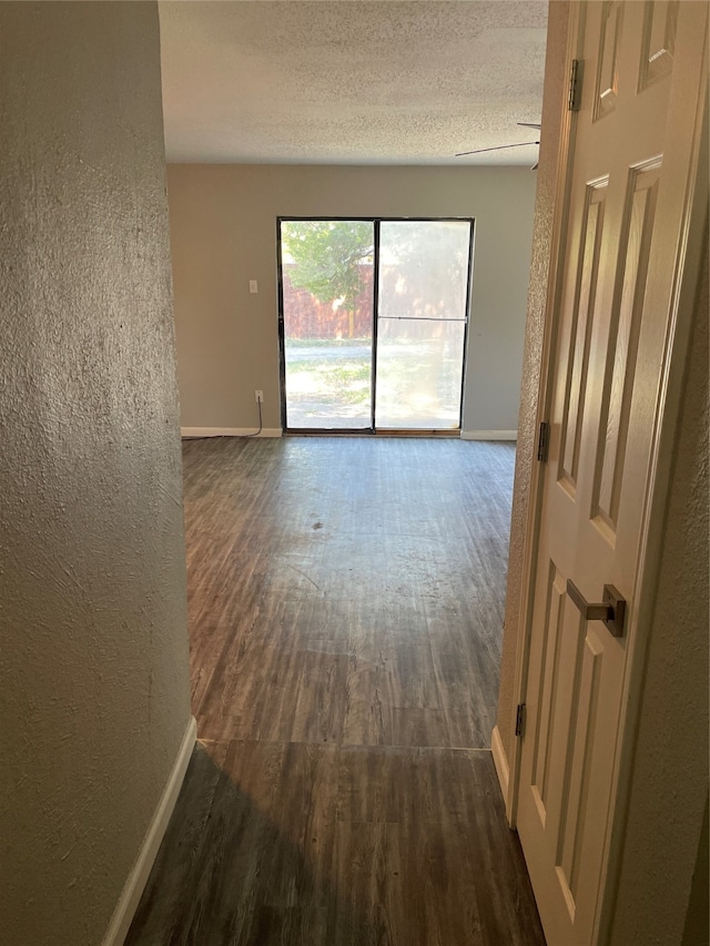 empty room featuring dark hardwood / wood-style floors and a textured ceiling