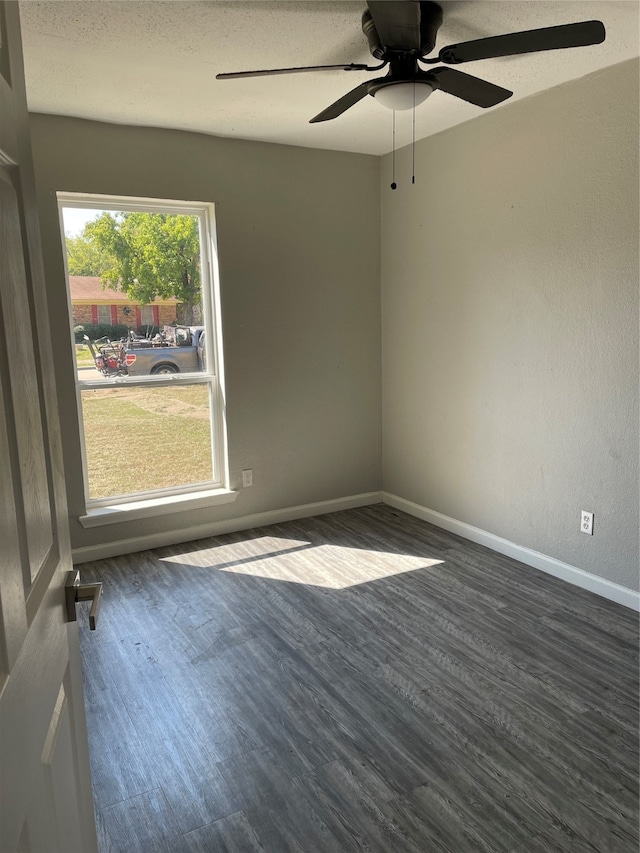 unfurnished room with ceiling fan, dark wood-type flooring, and a textured ceiling