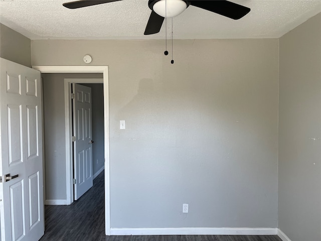 spare room featuring ceiling fan, a textured ceiling, and dark wood-type flooring