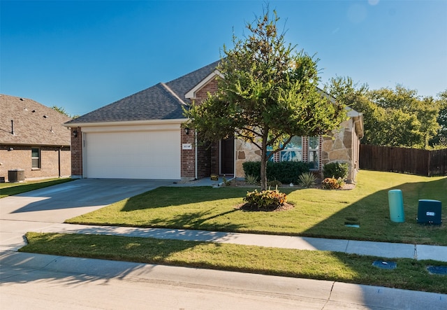 view of front of home with a front yard, central AC unit, and a garage