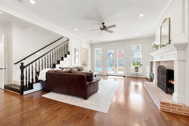 living room with hardwood / wood-style flooring, a fireplace, and crown molding