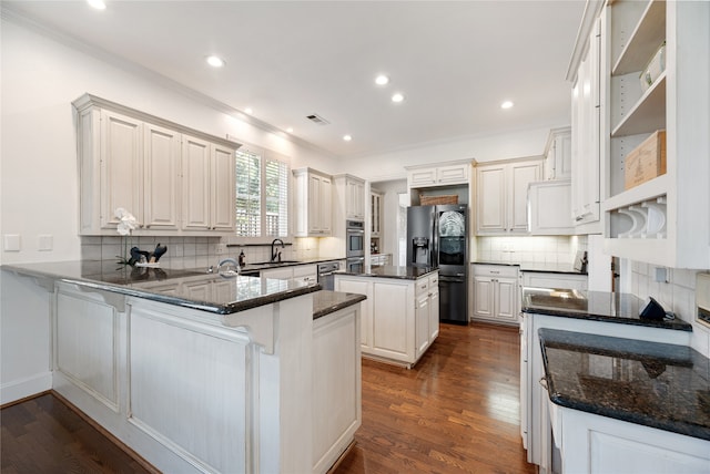 kitchen featuring a center island, dark hardwood / wood-style floors, kitchen peninsula, white cabinetry, and appliances with stainless steel finishes