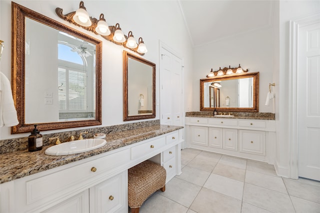 bathroom featuring ceiling fan, vanity, tile patterned flooring, and vaulted ceiling