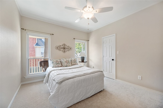 carpeted bedroom with ceiling fan and ornamental molding