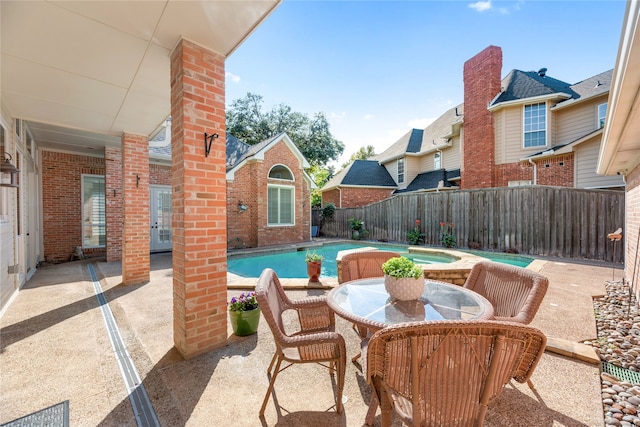 view of patio / terrace featuring a pool with hot tub