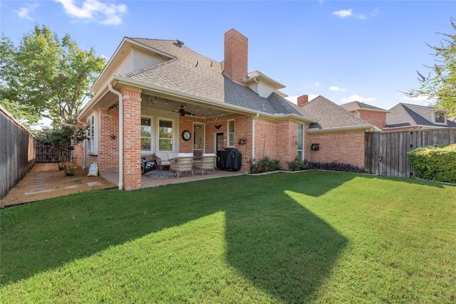 back of property with a yard, ceiling fan, and a patio