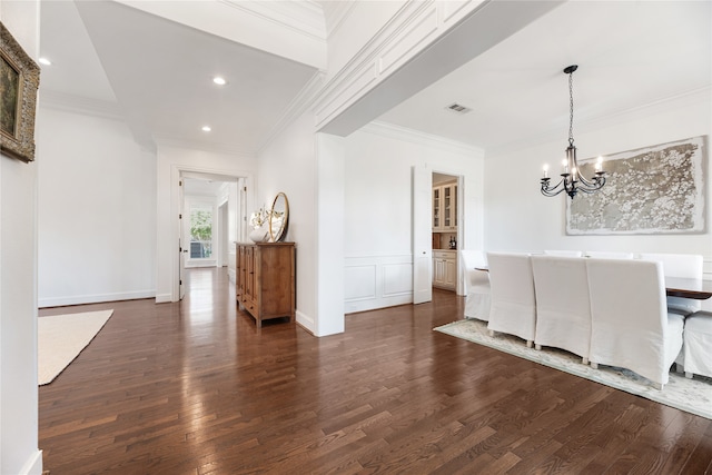 unfurnished dining area featuring ornamental molding, an inviting chandelier, and dark wood-type flooring