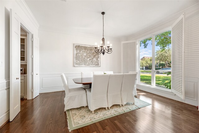 dining space with ornamental molding, an inviting chandelier, and dark hardwood / wood-style floors